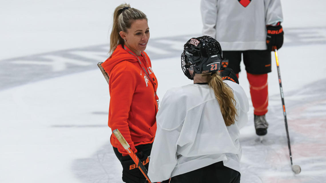 Cara Morey women’s ice hockey head coach talks to a plaey on the ice
