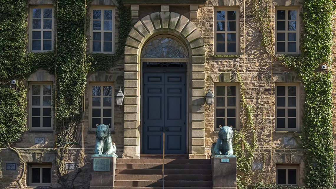 NassauHall_endowment_returns_2025.jpg The ivy-covered front door of Nassau Hall, flanked by two bronze tiger statues.