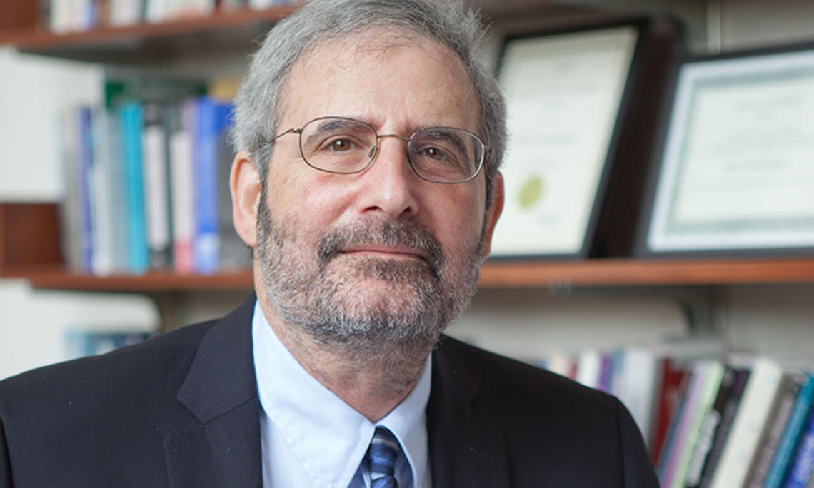 This is a headshot photo of Mark Beissinger, with a bookcase in the background.