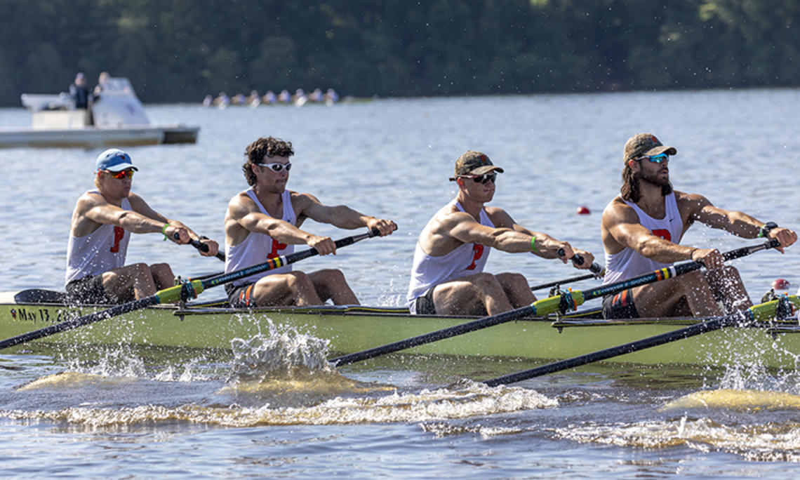 Four rowers from an eight man boat in action at a rowing regatta