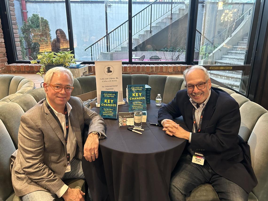 Photo of Bill Rosenblatt and Howie Singer sitting around a table with their book "Key Changes"