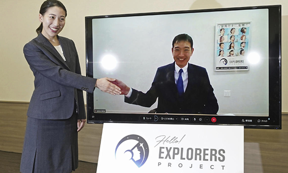 Ayu Yoneda (left) virtually “shakes hands” with Makoto Suwa *07 during a press conference in Tokyo on Feb. 28, after the Japan Aerospace Exploration Agency selected them to become astronauts.