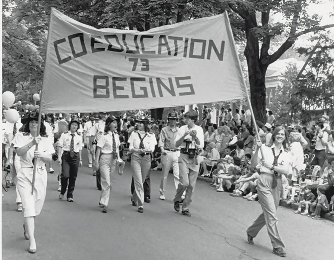 The Class of ’73 marches proudly with the “Coeducation Begins” banner at Reunions in 1983.