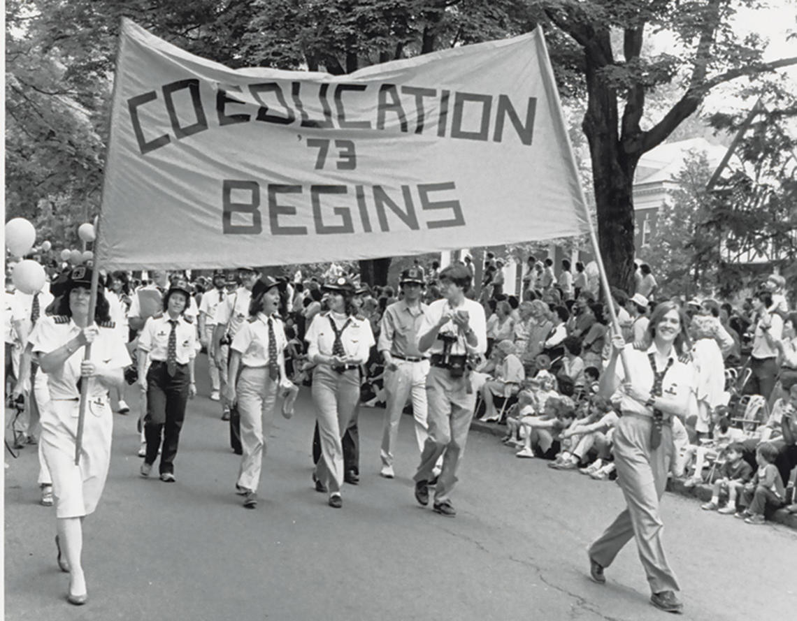 The Class of ’73 marches proudly with the “Coeducation Begins” banner at Reunions in 1983.