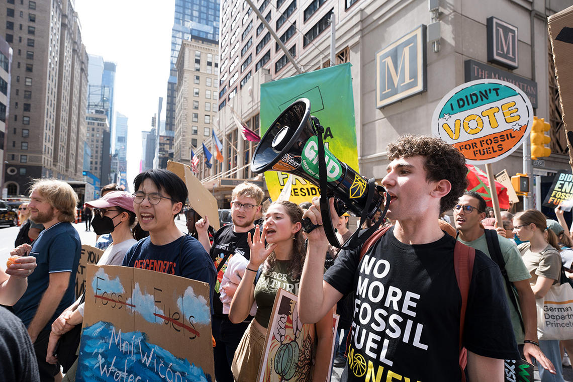 Princeton students on a street in New York City holding signs and bullhorn while marching