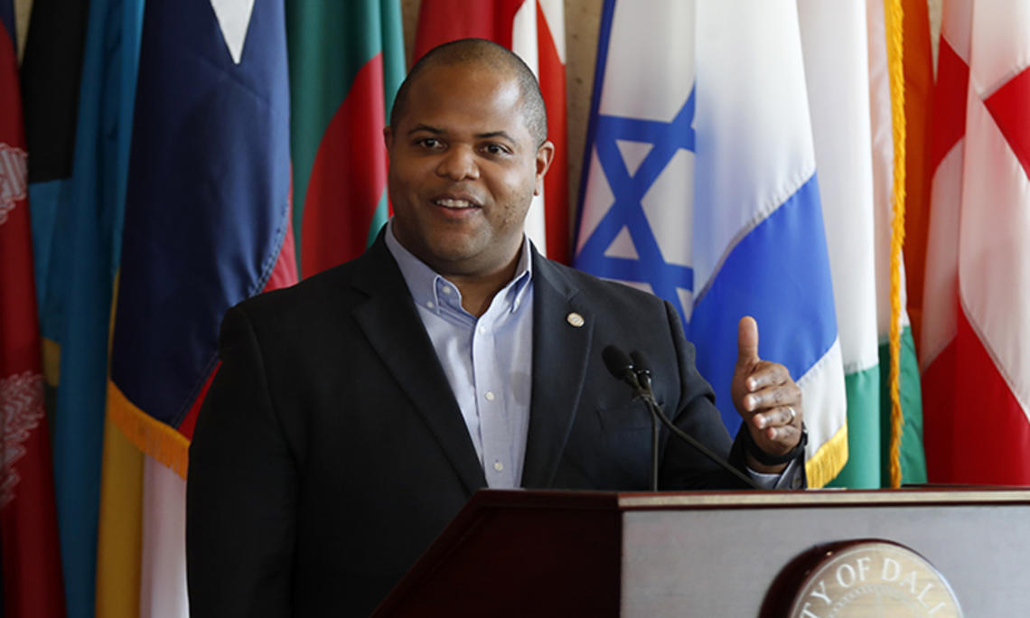 Dallas Mayor Eric Johnson *03 speaks at a podium.