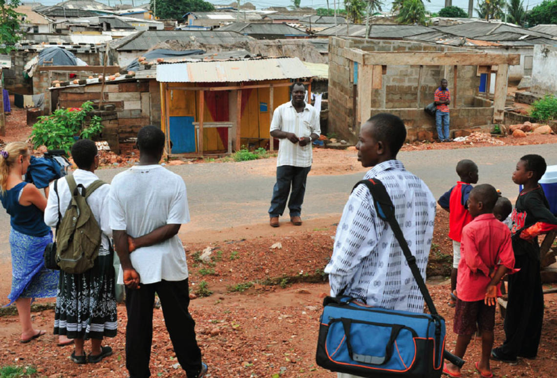 Professor Carolyn Rouse (second from left) documents elder Jacob Otabil’s tour of Oshiyie, Ghana, site of the school she is building. She notes that “what looks like poverty and suffering to some is challenged by Otabil’s description of a vibrant co