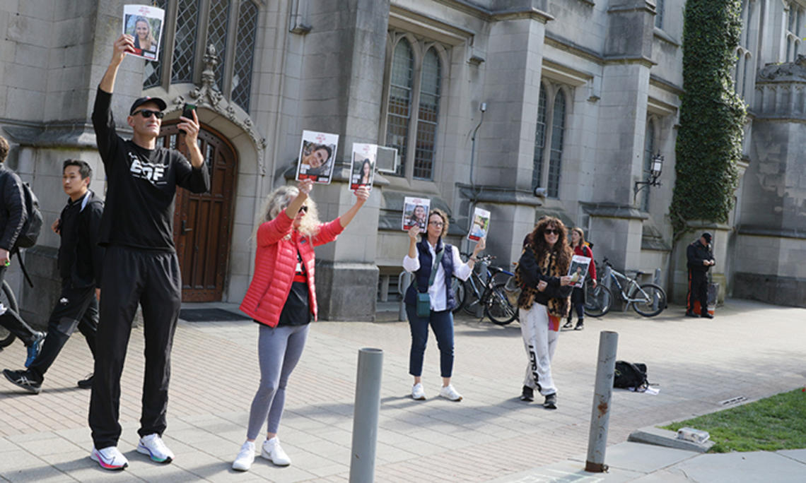 Howard Levy ’85, left, holds up photos of Israeli hostages at the pro-Palestinian student encampment in McCosh Courtyard on April 25.