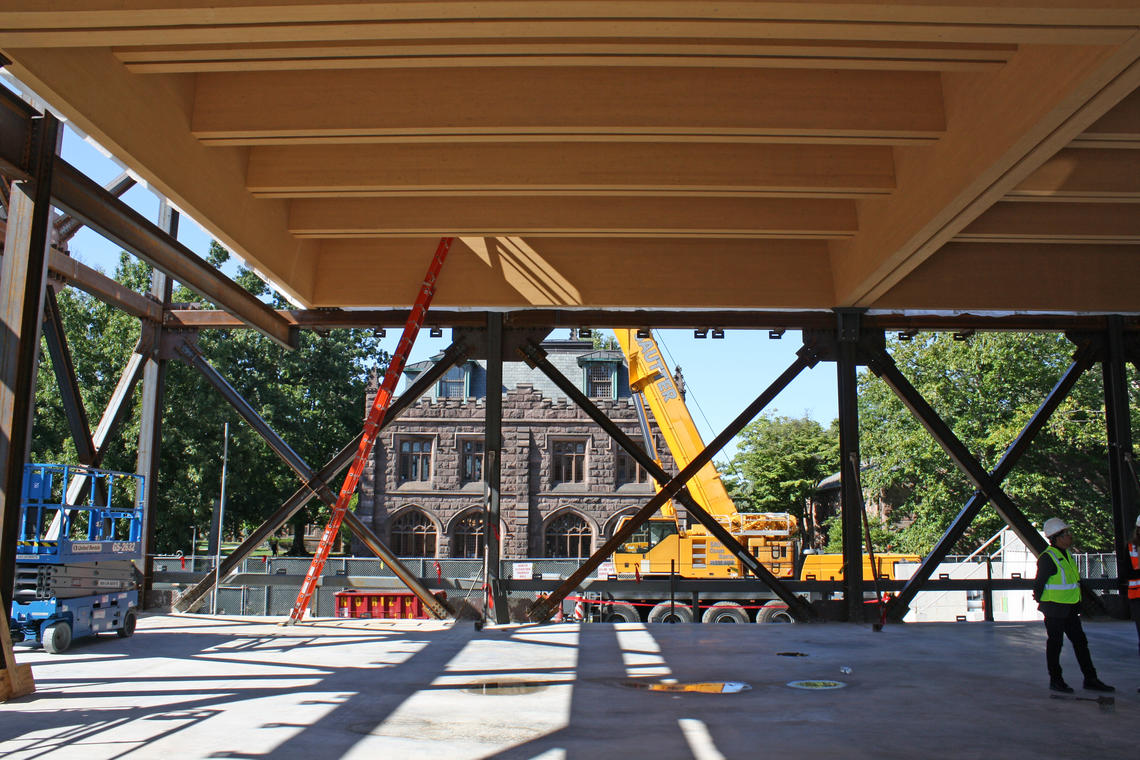 A Gothic Princeton building is visible through the framed-out construction of the art museum. A large piece of construction equipment is in the middle.