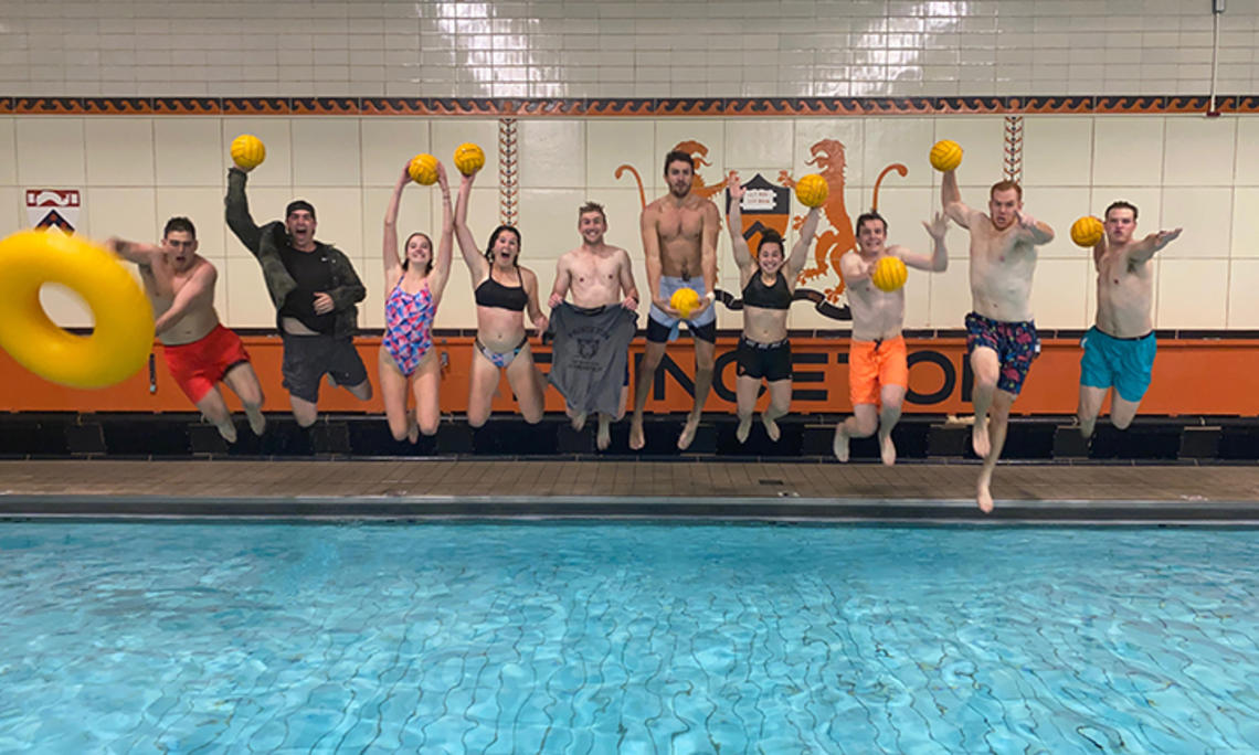 Holding yellow water polo balls, Princeton’s intramural water polo team jumps into the pool.