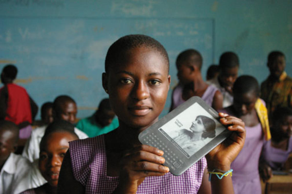 A girl in Ghana holds an e-reader provided by Worldreader.org.
