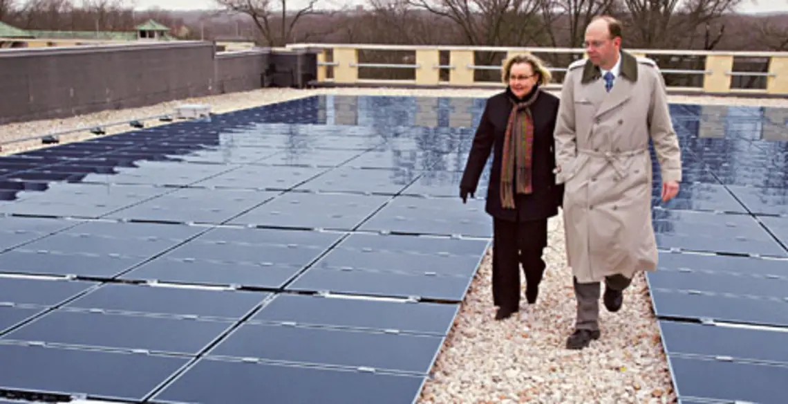 The roof of the Research Collections and Preservation Consortium’s storage library on the Forrestal campus houses the University’s largest solar-energy installation. Shown are Eileen Henthorne, the consortium’s executive director, and Tom Nyquist, P