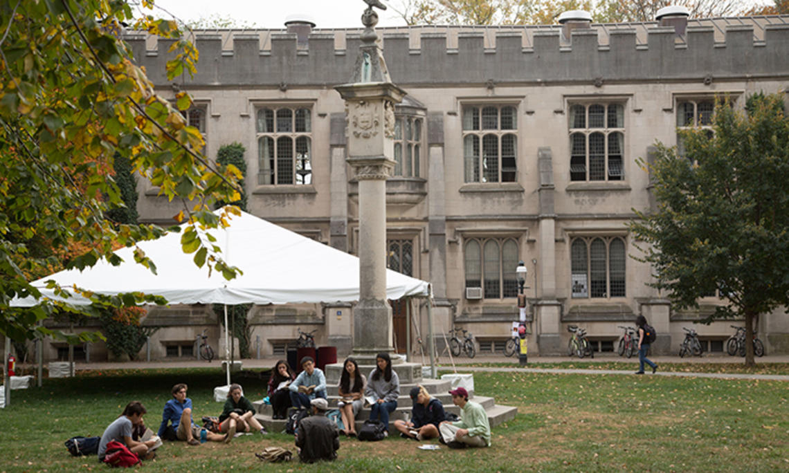 Students sit on the steps and on the ground at the base of the Mather Sundial.