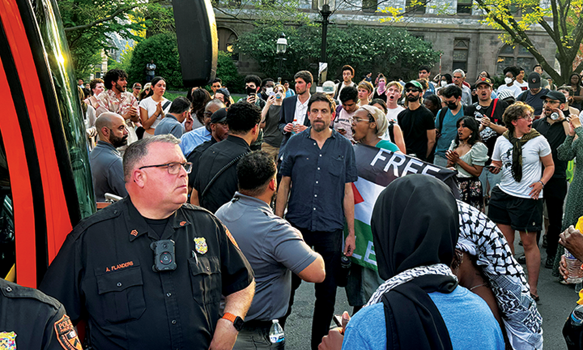 Max Weiss, a professor of history, stands at the April 29 Clio Hall occupation between protesters and Public Safety officers, who detained a student and a postdoc in a University bus.