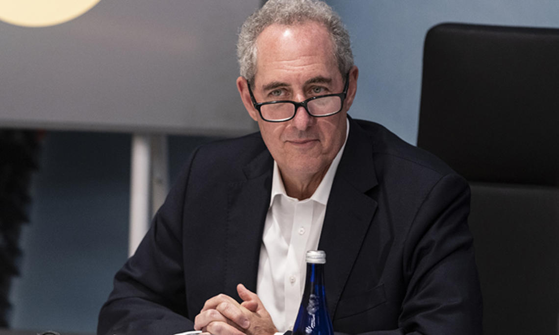 Michael Froman ’85 folds his hands while sitting at a table.