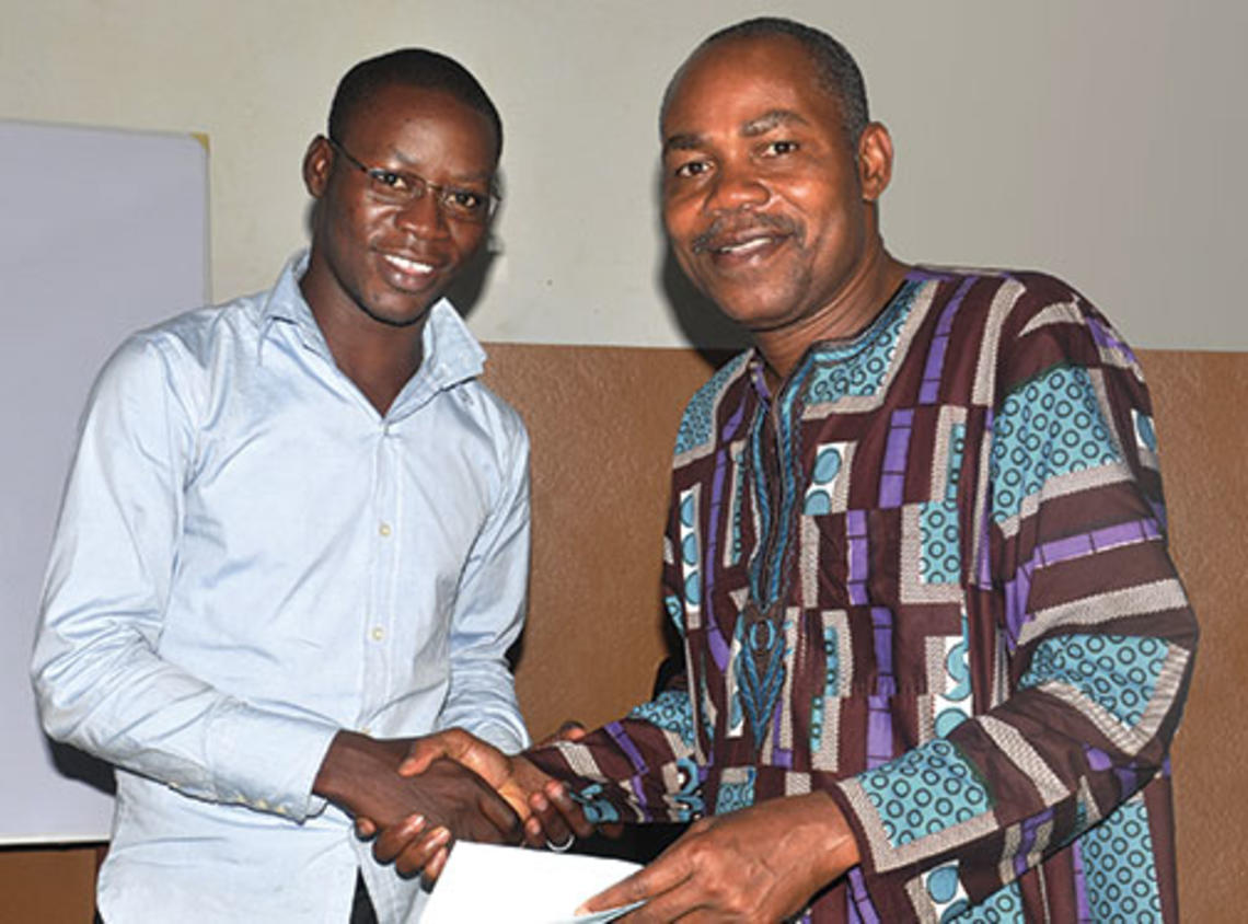 Leonard Wantchekon, right, congratulates Romaric Samson on earning a master’s degree from the institute in Benin, West Africa, that Wantchekon founded.