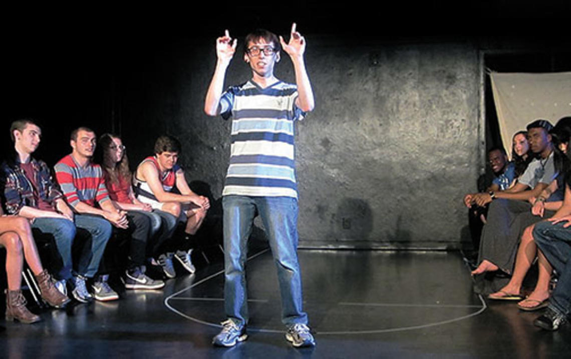 Patrick Roche ’14 performs on campus in 2013 as Ellipses Slam Team members look on.