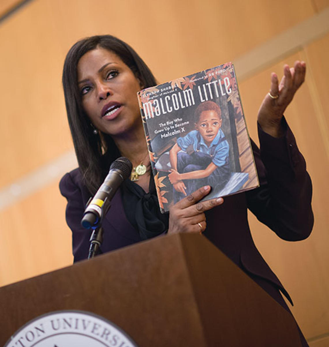 Ilyasah Shabazz with a book she wrote about her father, Malcolm X, as a child