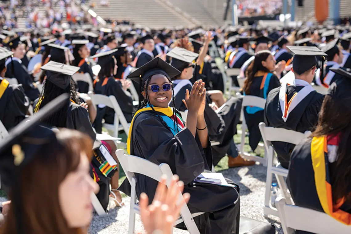Graduate clapping in crowd