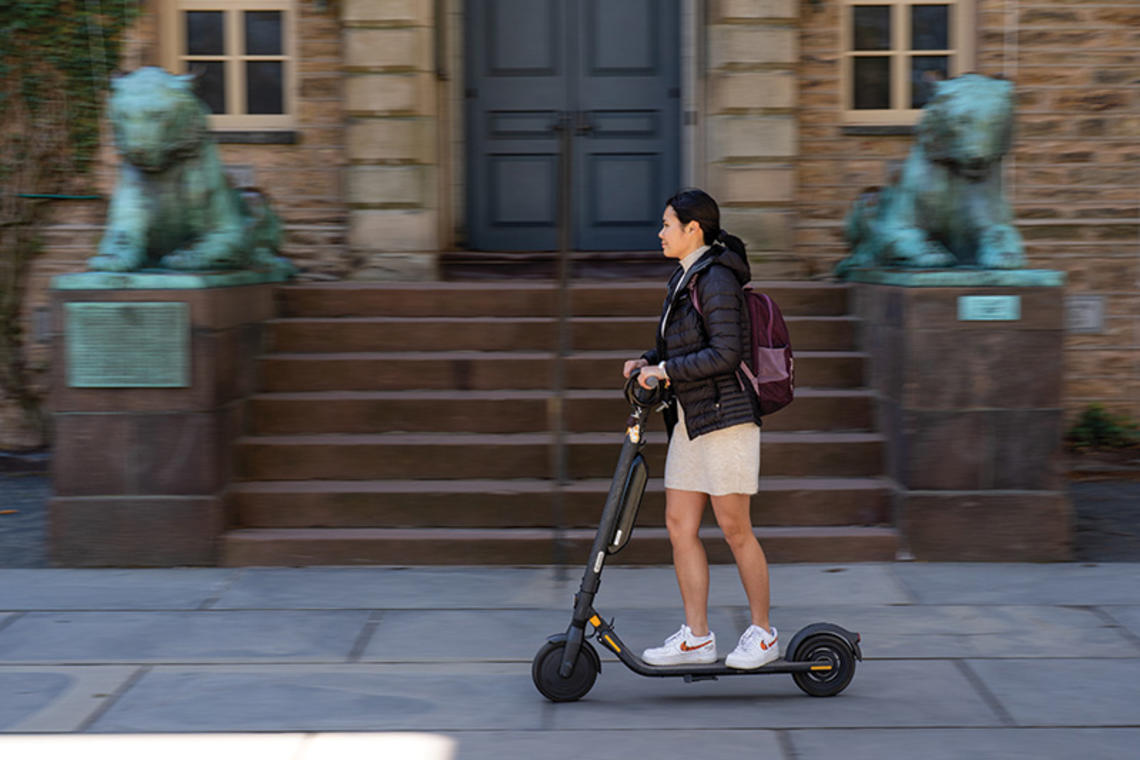 Student riding electric scooter