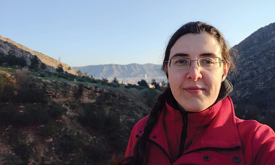 Elizabeth Tsurkov standing by a mountain landscape