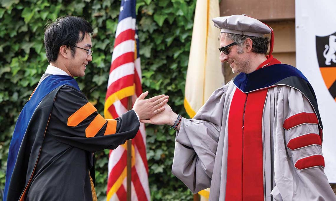 Yifan Zhang *22, left, receives a high five from chemistry professor Mohammad Seyedsayamdost