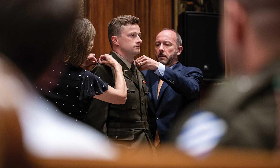Parents Julie and Scott Thompson pin the rank insignia on 2nd Lt. Bennett Thompson ’22