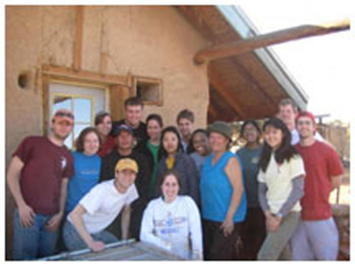 Students who took part in the Breakout trip to Big Mountain, Arizona, a community on the Navajo Nation Native American reservation, stand in front of a home and straw bale that they worked on as part of their sustainable building project.  From left are T