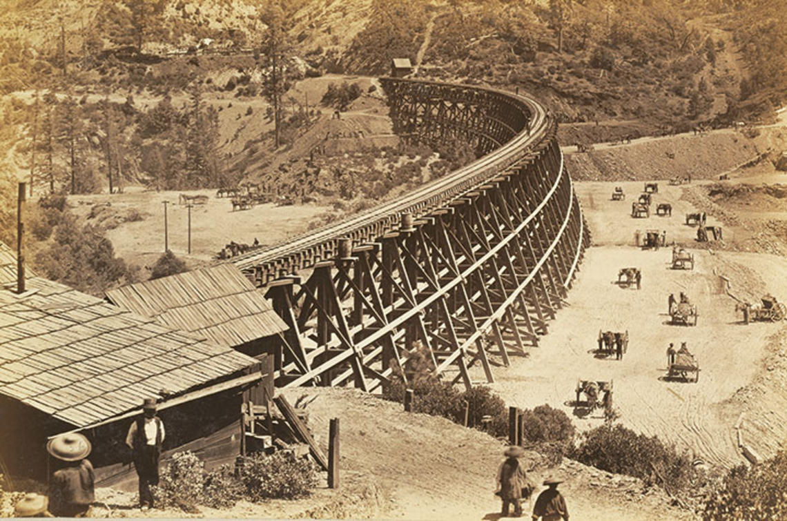 Chinese workers fill in a ravine alongside a large trestle for the Transcontinental Railroad in this photo, taken in 1867.