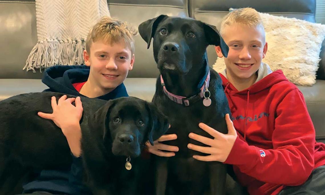 Professor Joshua Akey’s sons, Matthew, left, and Nicholas, right, with their dogs, Zoey, left, and Abby, right.