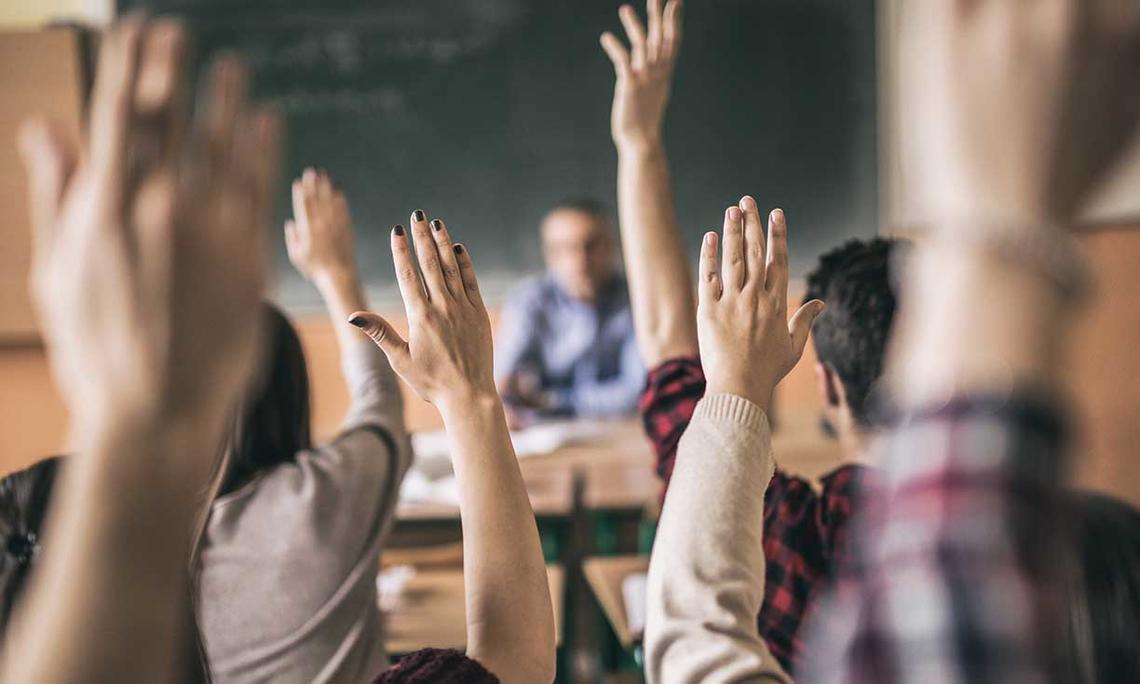 Photo of hands raised in a classroom