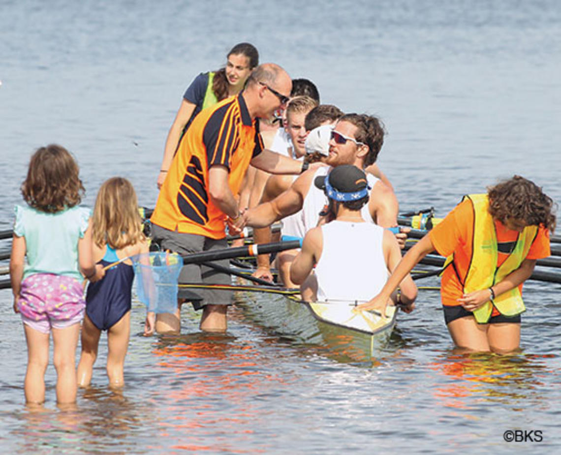 Coach Greg Hughes ’96 congratulates the men’s heavyweight varsity eight.