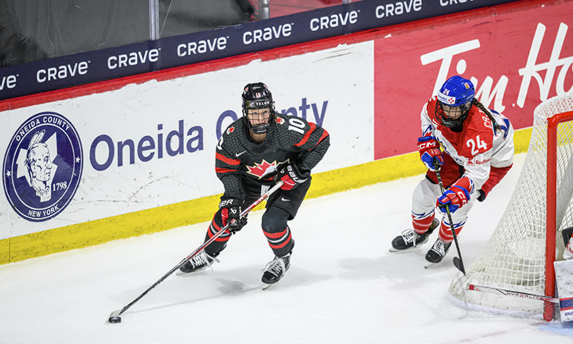 SarahFillier.jpg Two hockey players skate around the back of the goal.
