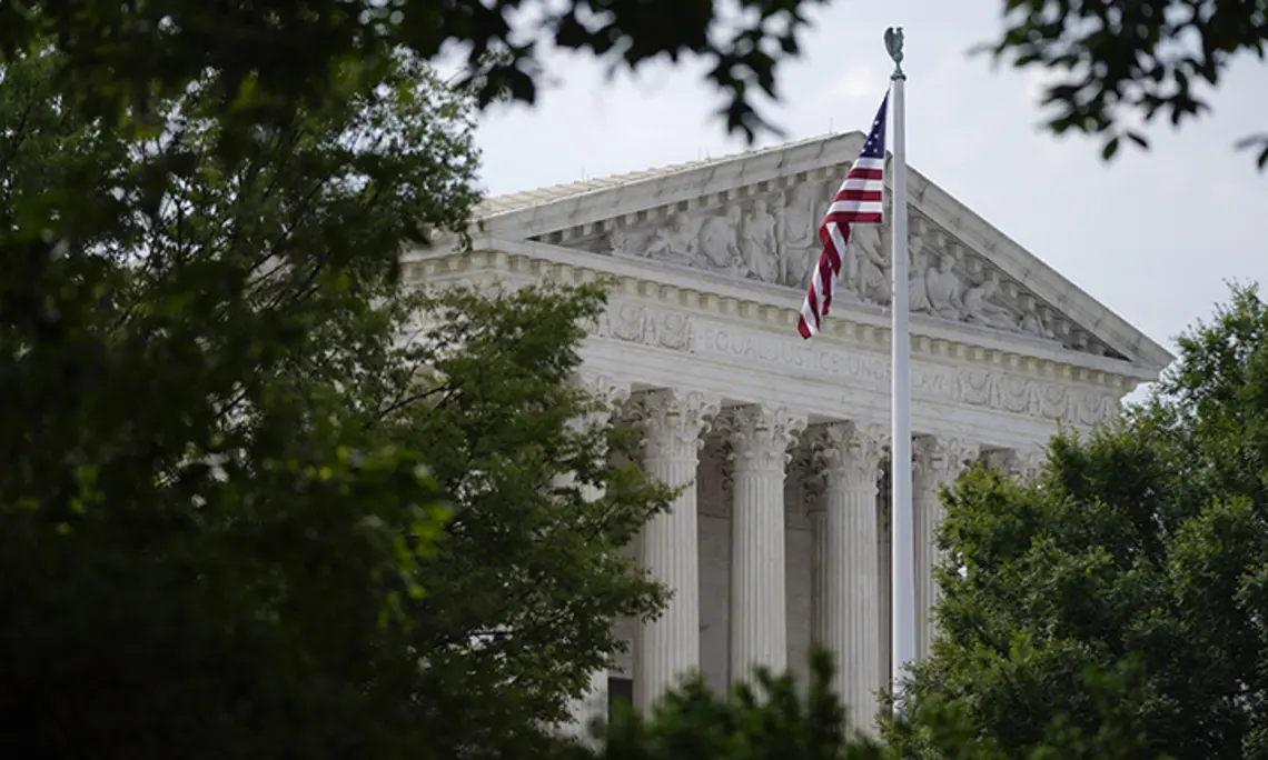 An American flag waves in front of the U.S. Supreme Court building, Monday, June 27, 2022, in Washington.