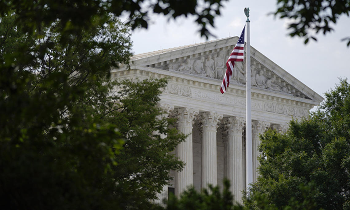 An American flag waves in front of the U.S. Supreme Court building, Monday, June 27, 2022, in Washington.