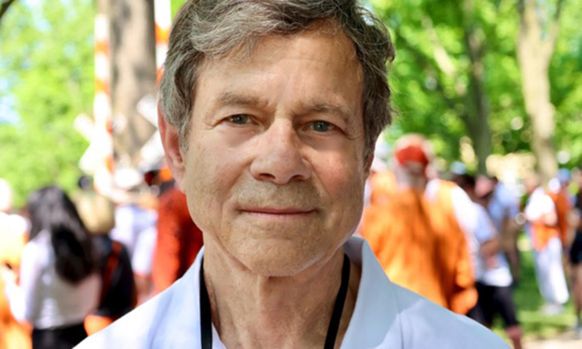 This is a headshot photo of Alan Lightman with Princeton Reunions in the background.