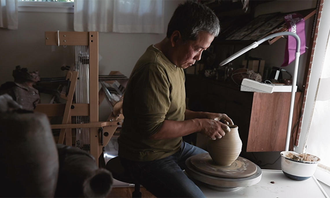Hideo Mabuchi makes a vase on his pottery wheel.