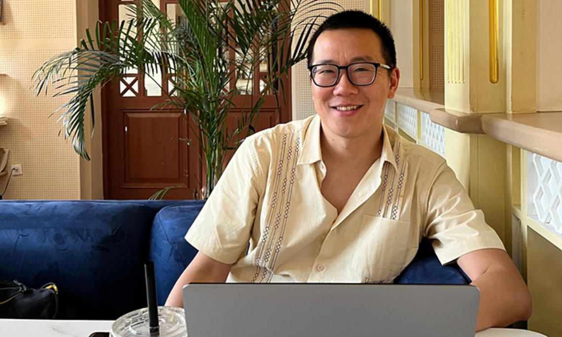 TOW_JonathanCheng.jpg Jonathan Cheng ’05 smiles up from his laptop computer.