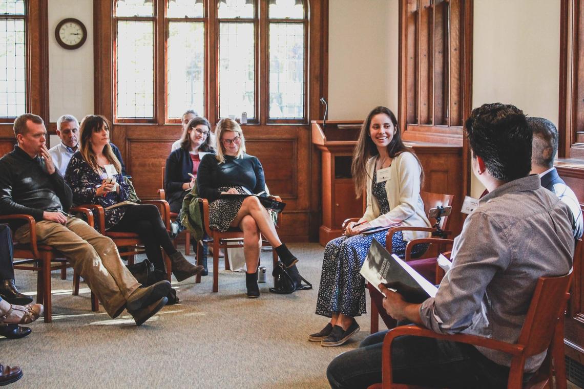 Katherine Clifton ’15 sits in the center of a group of about eight people.