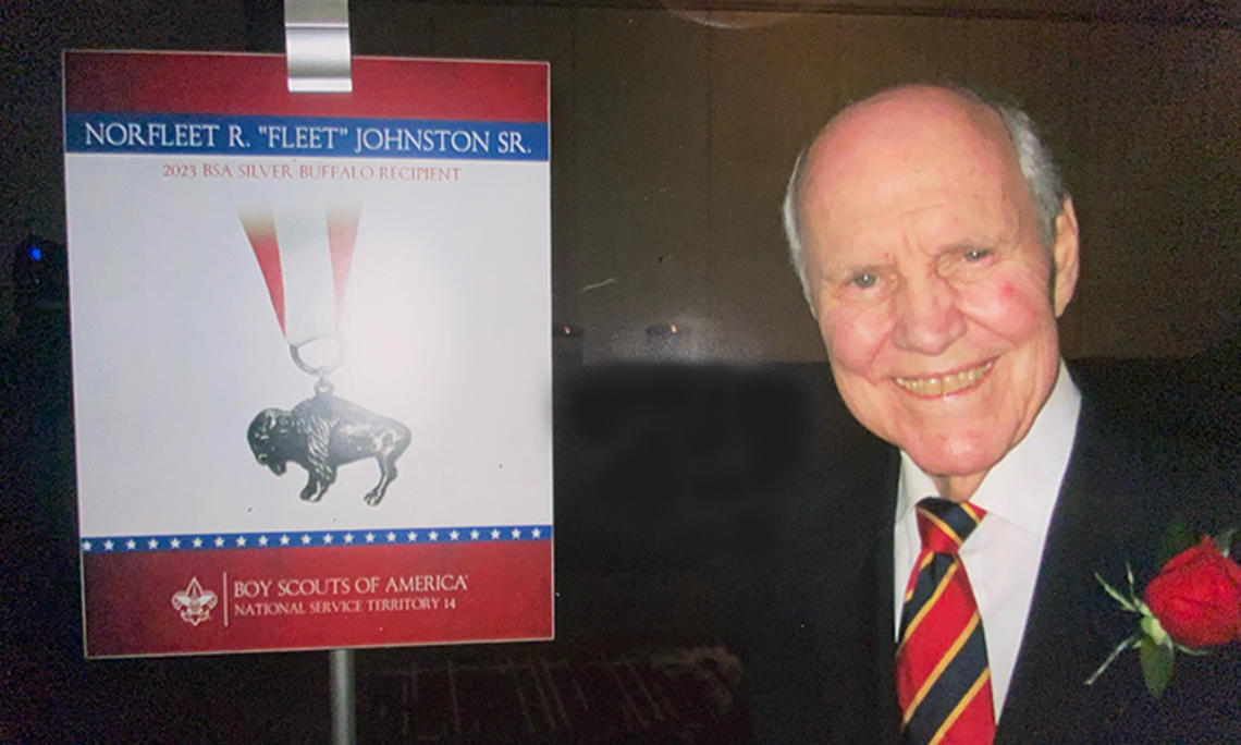 TOW_NorfleetJohnson.jpg Norfleet Johnson ’56 next to a sign from the Boy Scouts of America about his Silver Buffalo award.