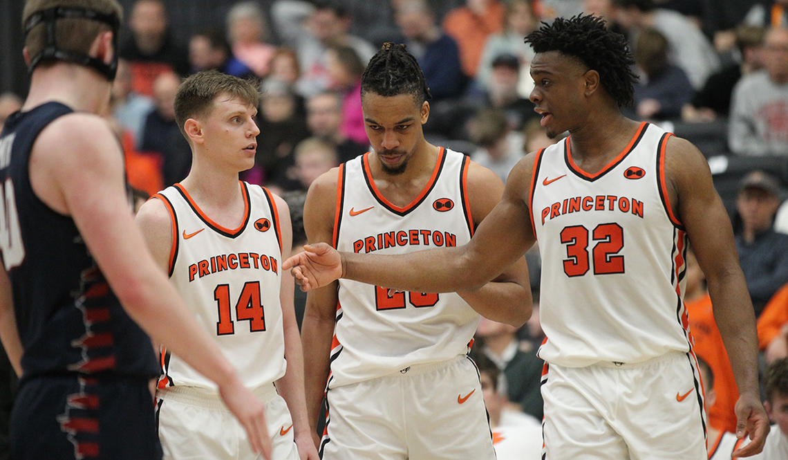 Left to right, Matt Allocco ’24, Tosan Evbuomwan ’23, and Keeshawn Kellman ’23 talking on the court at Jadwin Gym