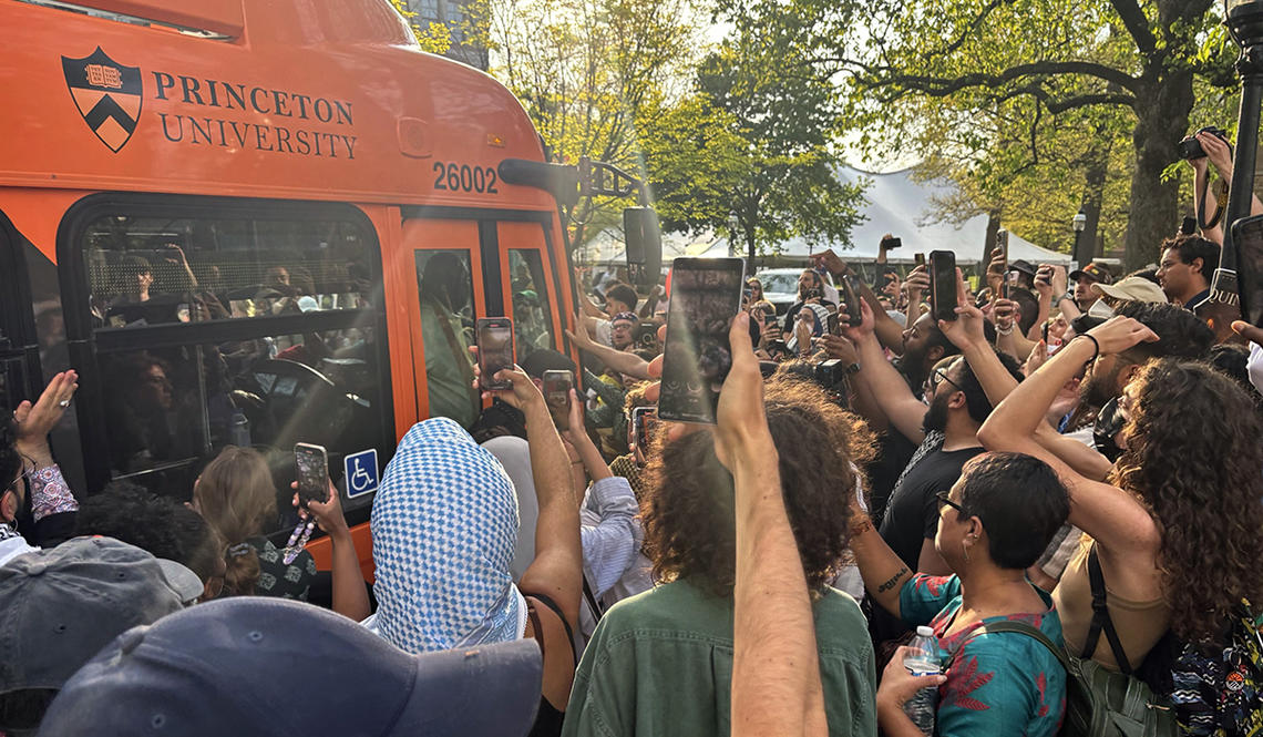 bus-042924.jpg Protesters surrounding a University bus, holding up cell phone cameras