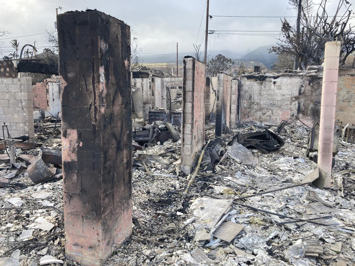 Miles Patrie’s house after the fire; in between charred cinderblock walls and posts are ash and burned building materials on the ground.