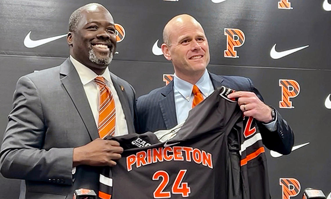 Athletics director John Mack ’00, left, and men’s hockey coach Ben Syer, right hold a Princeton hockey jersey at an April 26 press conference. 