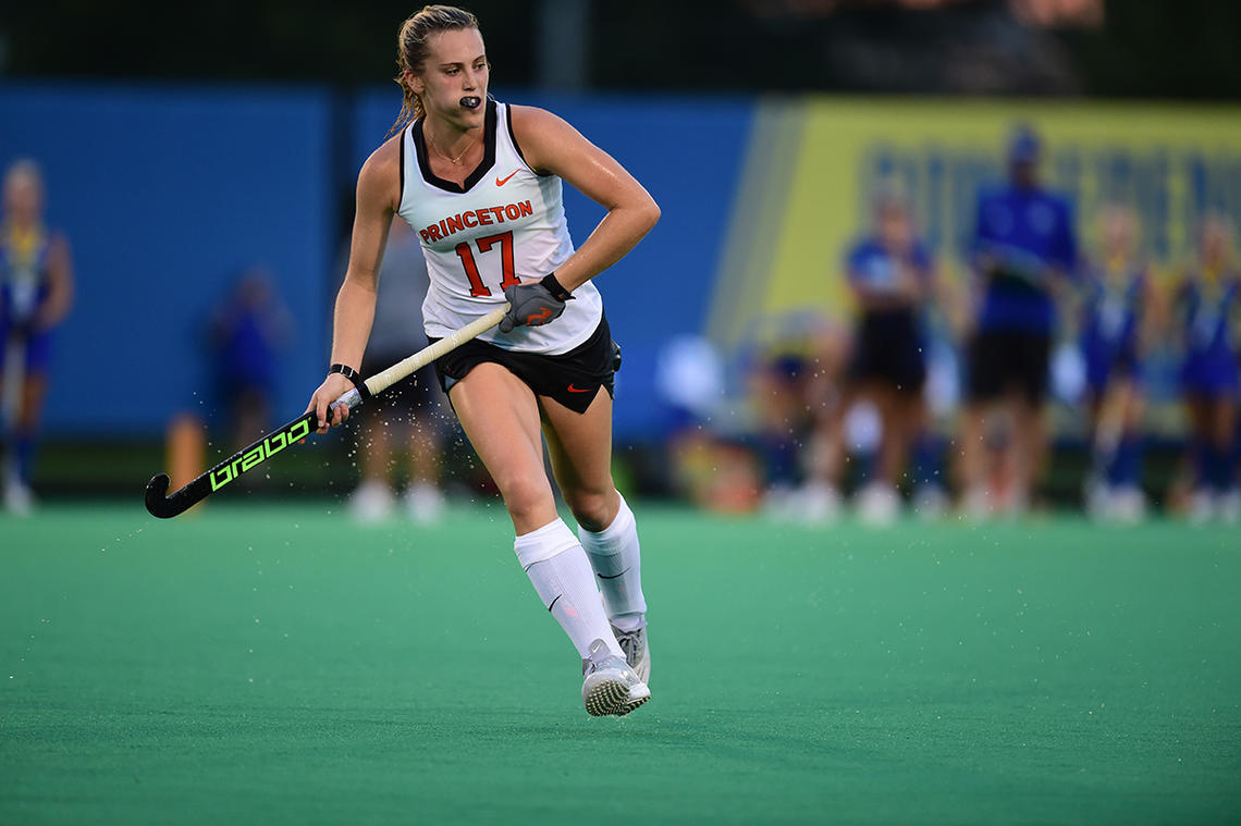 Field hockey player Beth Yeager '26 running and holding hockey stick