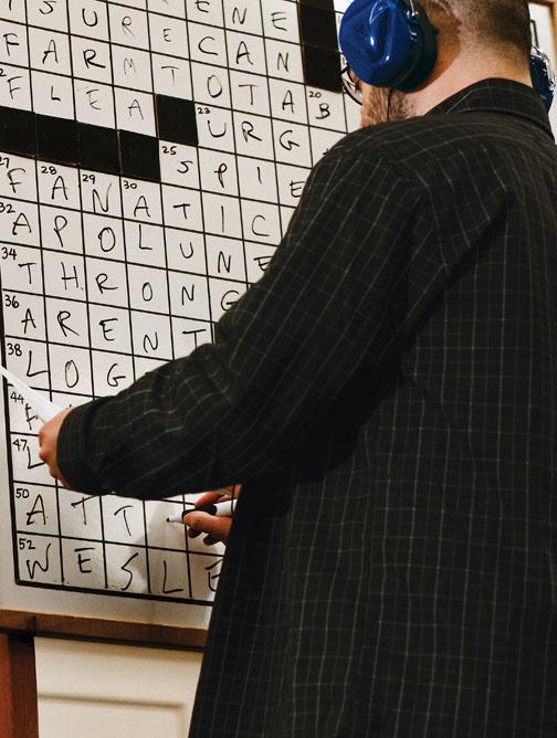 Wearing noise-canceling headphones, Dan Feyer ’99 finishes his puzzle to win the national crossword competition in March.
