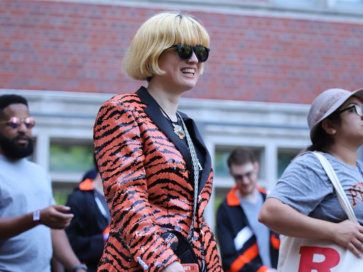 A woman wears an orange-and-black tiger-striped sequined jacket.