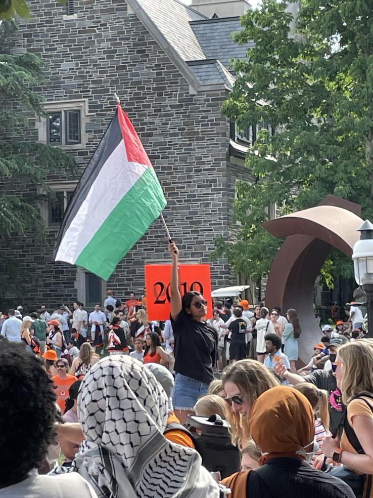 A protester by the Class of 2019 at the P-rade holds up a Palestinan flag.