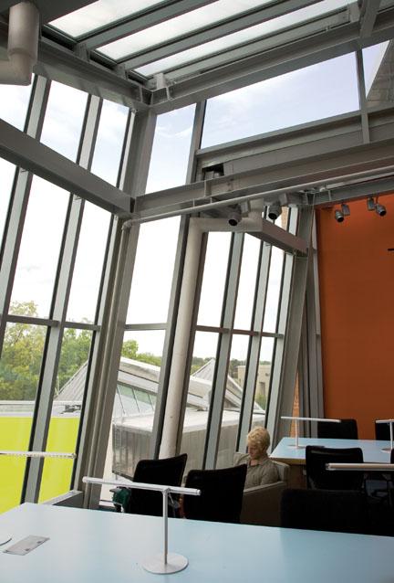 From this study area on the top level, students can take in the stainless-steel roof and different shapes of the building visible outside, and the campus beyond.