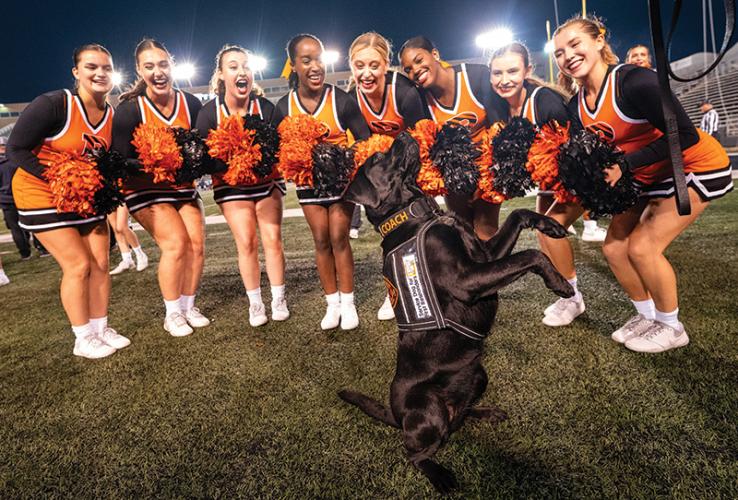 Coach the dog with cheerleaders